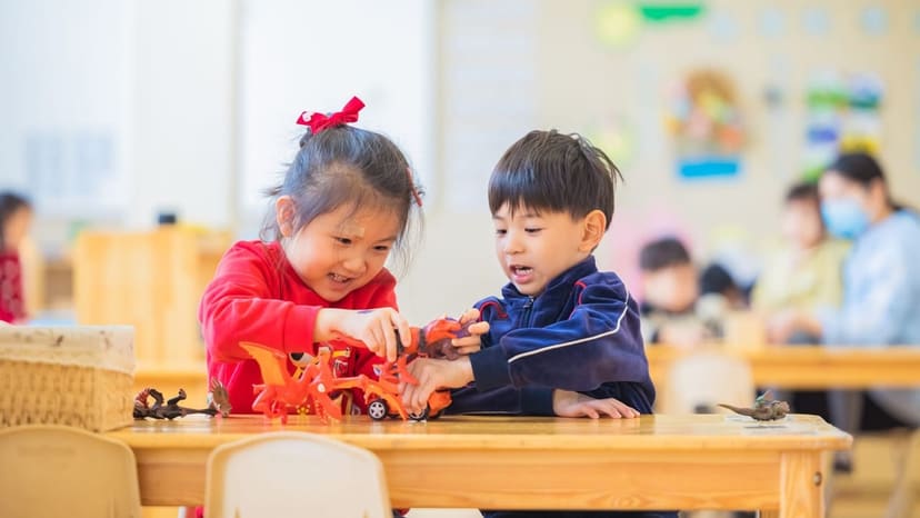 園の机で、子ども2人がおもちゃで遊んでいる