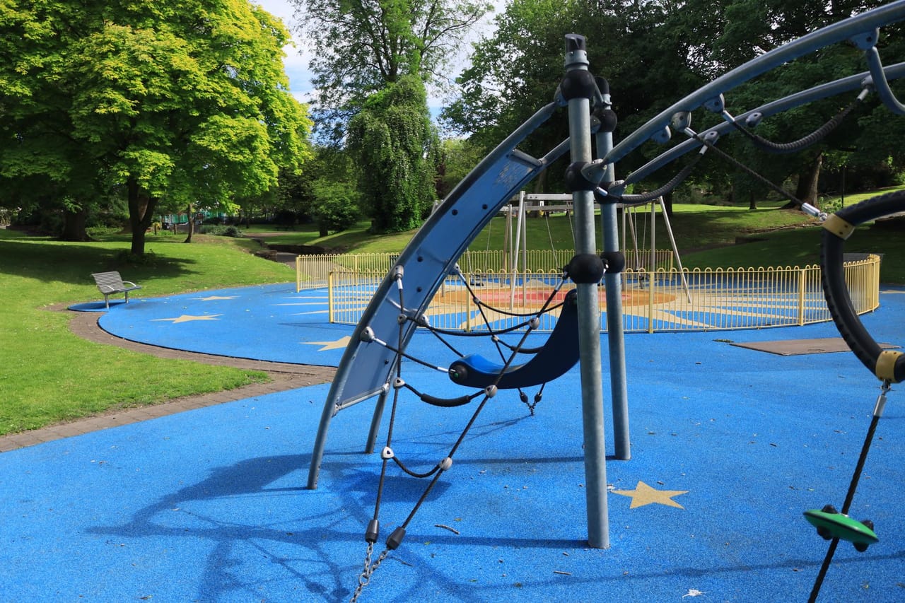 遊具の足元を弾力のある青いゴムチップ舗装で仕上げた、公園の遊び場の写真